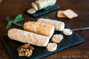 Several types of compound butter served in a log shape on slate platters.