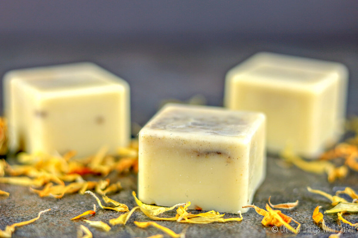 homemade dandelion infused lotion bars surrounded by dandelion petals