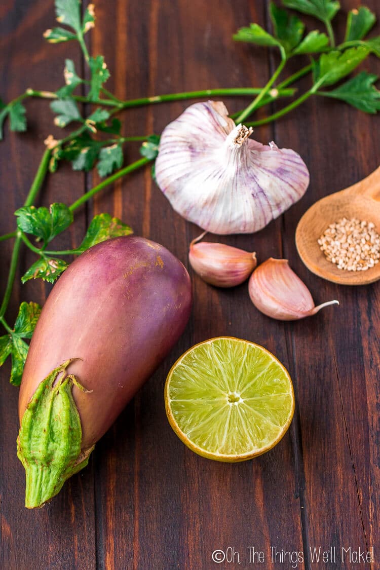 the ingredients for baba ganoush: eggplant, garlic, sesame seeds, and lemon or lime