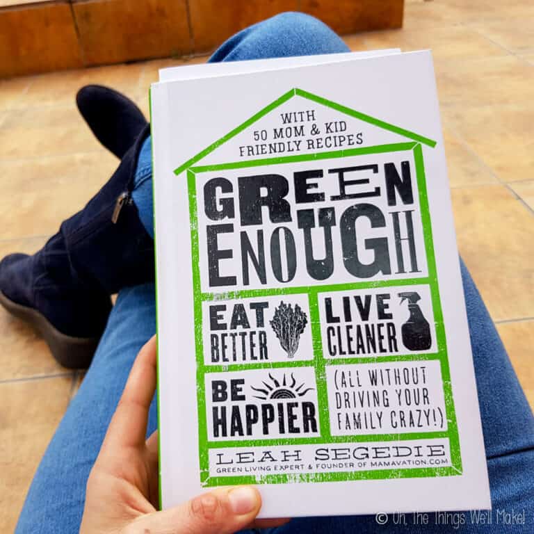 Photo of somebody holding the book "Green Enough" by Leah Segedie.