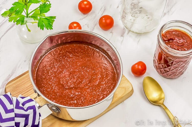 homemade easy barbecue sauce in a pan on top of a wooden cutting board.
