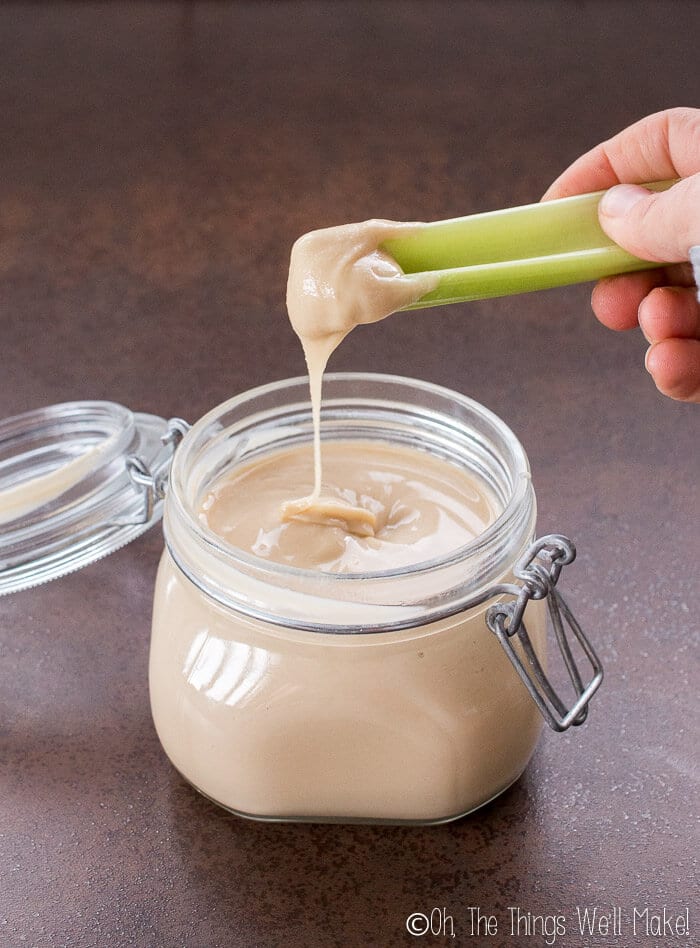 Raw almond butter drizzled off a stalk of celery.