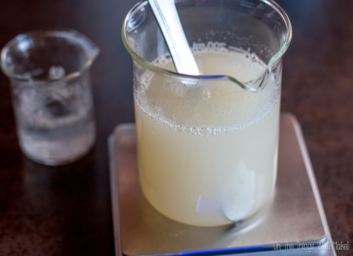 weighing out a mixture of natural surfactants on a scale while making shampoo.