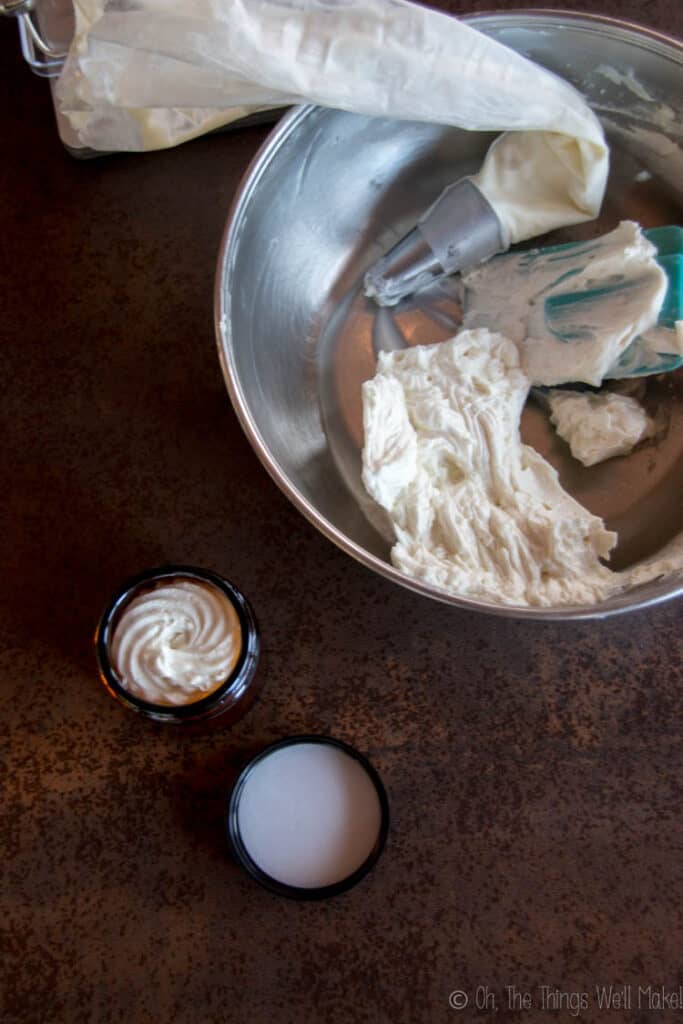 Transferring the homemade hair butter to glass jars using a piping bag and tip to make a decorative top.