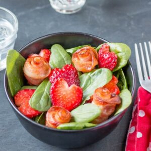 A salad with bacon roses and strawberry hearts