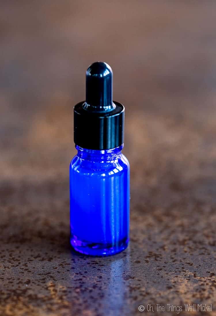 a blue glass bottle with dropper top filled with a homemade hyaluronic acid serum