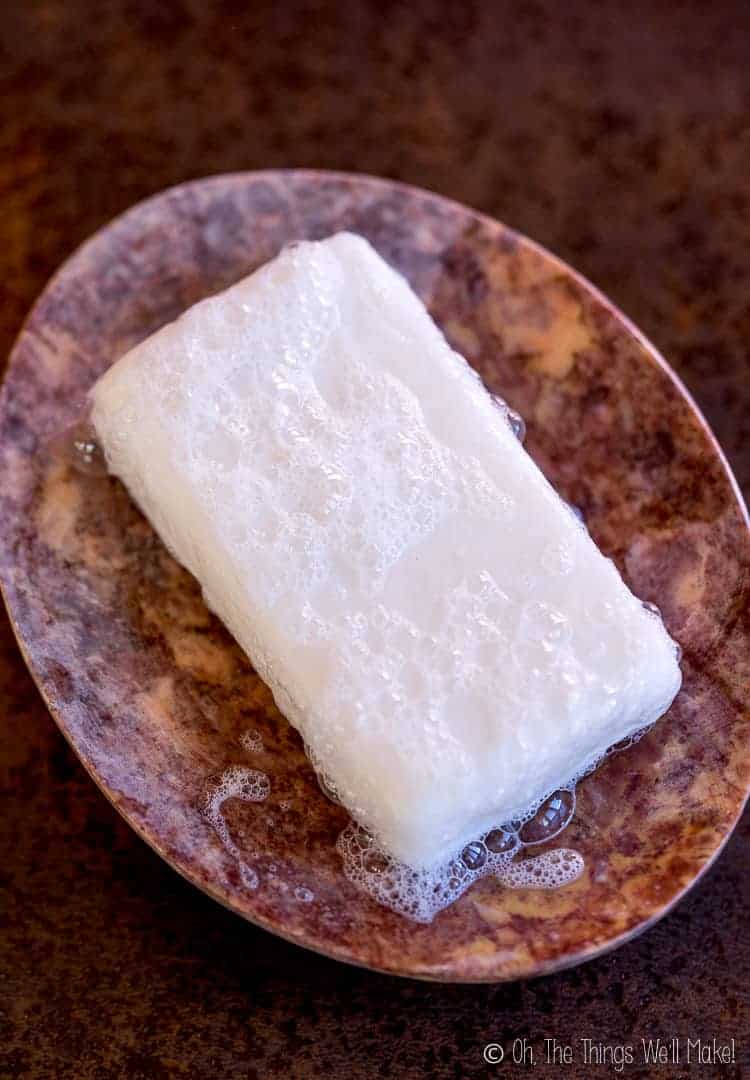 Closeup of a homemade shampoo bar in a stone soap dish.