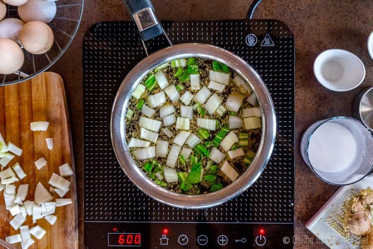 overhead view of chicken broth with bok choi and ginger.