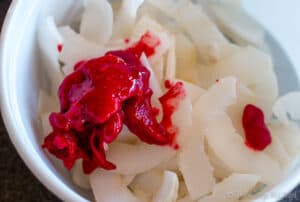 Adding a dollop of raspberry puree to some homemade coconut chips
