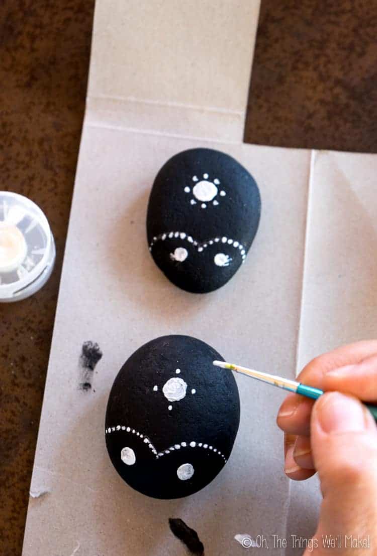 Painting small dots evenly spaced around the larger center dot.