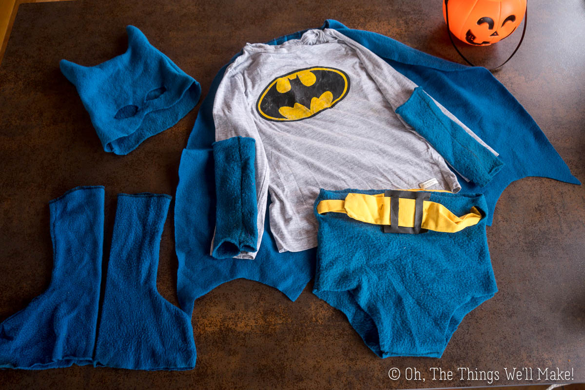 A homemade Batman costume consisting of a mask, a long-sleeved shirt with the Batman logo, a cape, a pair of arm cuffs, and bottoms with a belt.