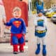 A young boy in a Superman costume and a boy in a Batman costume
