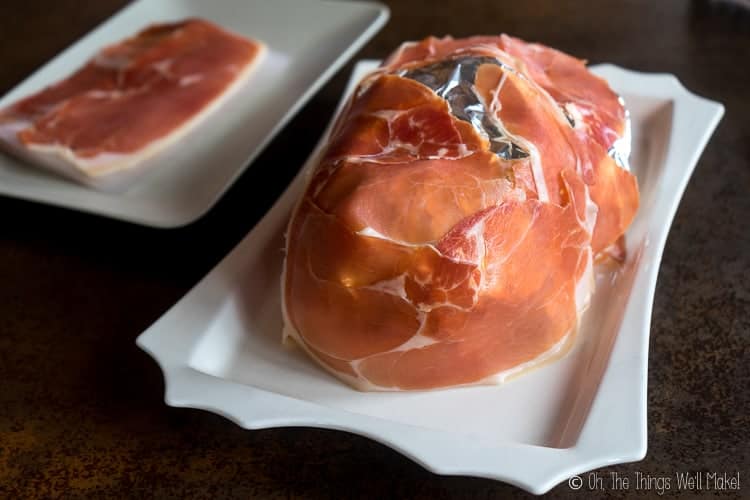 wrapping the face with proscuitto ham, taking care to wrap around the bottom edges.
