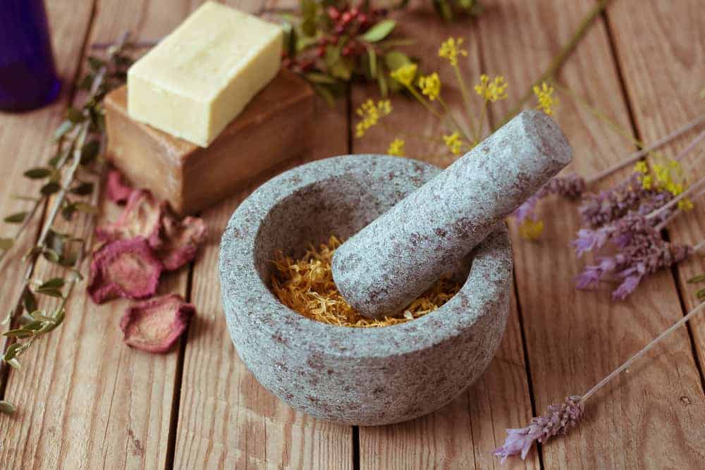 photo of marble wortar and pestle with herbs, dried flowers, and homemade soap