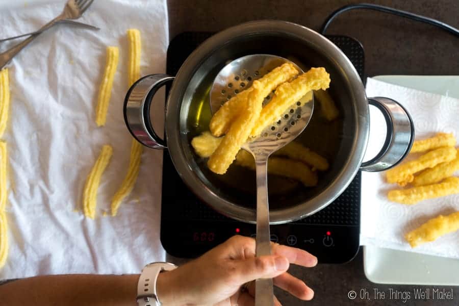 removing cooked gluten-free churros from the hot olive oil