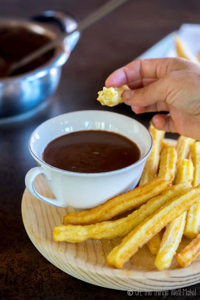 homemade churros on a plate with a cup of homemade Spanish hot chocolate.