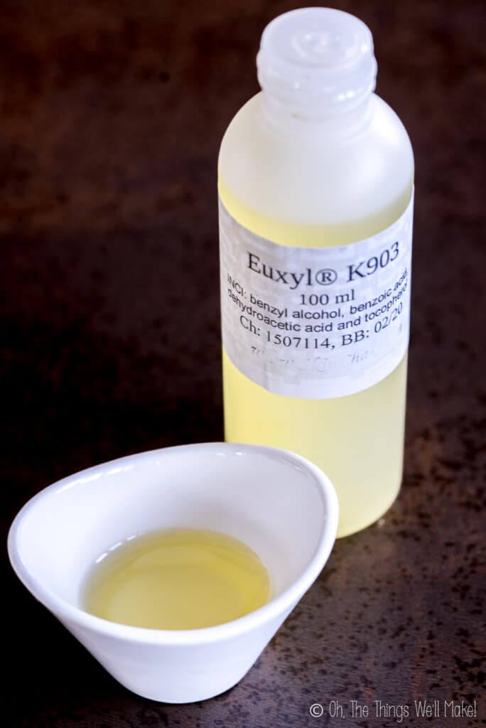 Euxyl K903 in a small bowl in front of a bottle of it.