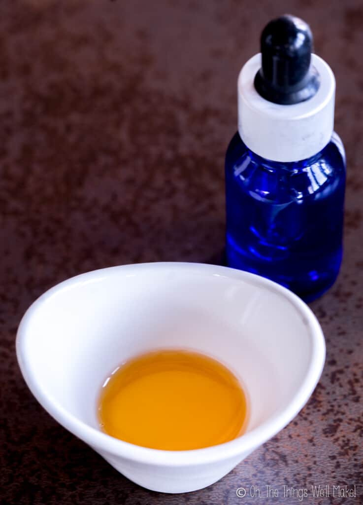 A small bowl of Geogard ® 221 (aka. Cosgard) in front of a glass bottle