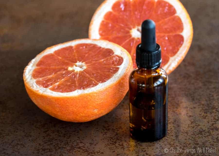 A bottle of grapefruit seed extract in front of a cut grapefruit