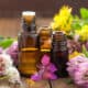 Several open glass vials surrounded by fresh flowers