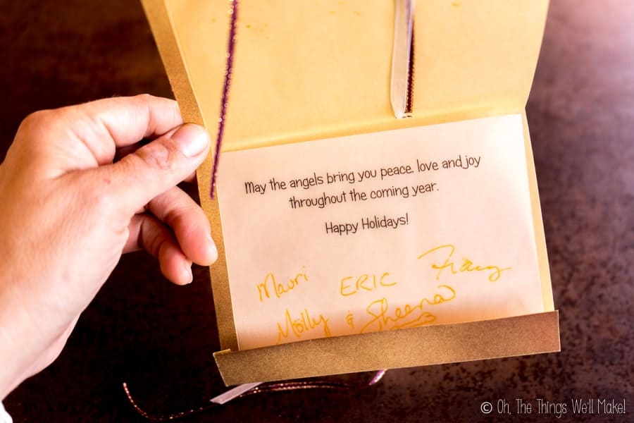 An open Christmas cards with the text "May the angels bring you peace, love, and joy throughout the coming year."