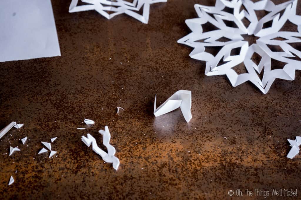 A folded paper that has been cut for making a paper snowflake, ready for unfolding