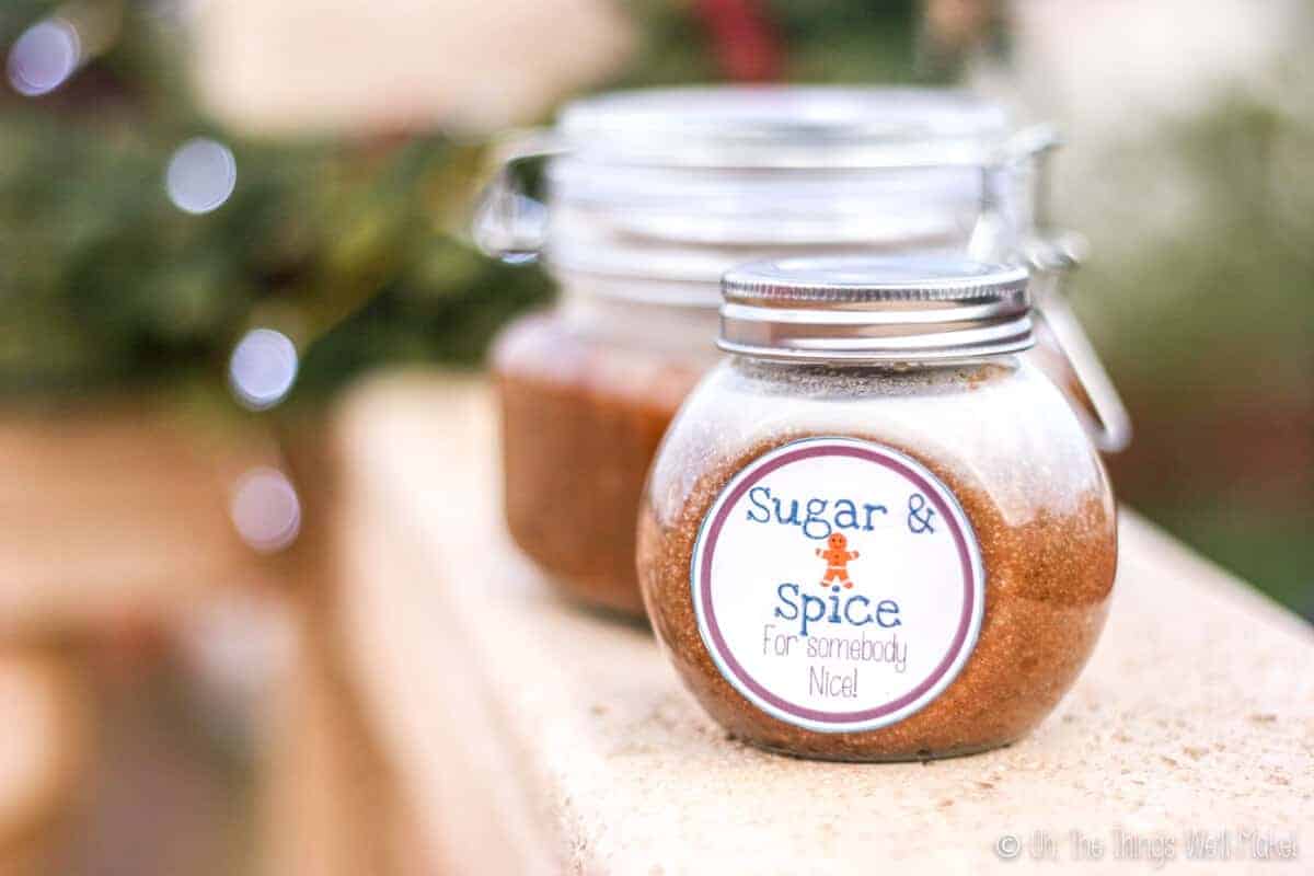 Two jars of a homemade sugar body scrub, one with a label that says "Sugar and Spice for somebody nice."