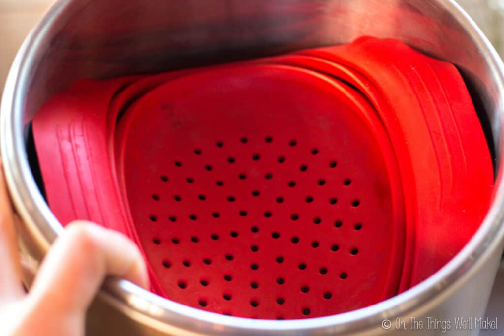 Closeup of a silicone strainer in a stainless steel pot