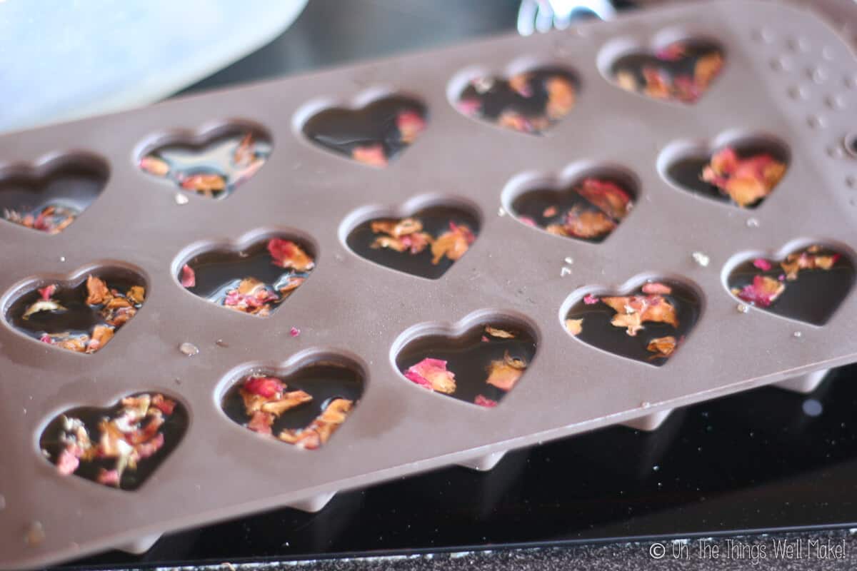Close up of a hearts shaped mold filled with gelatin and rose petals on the top.