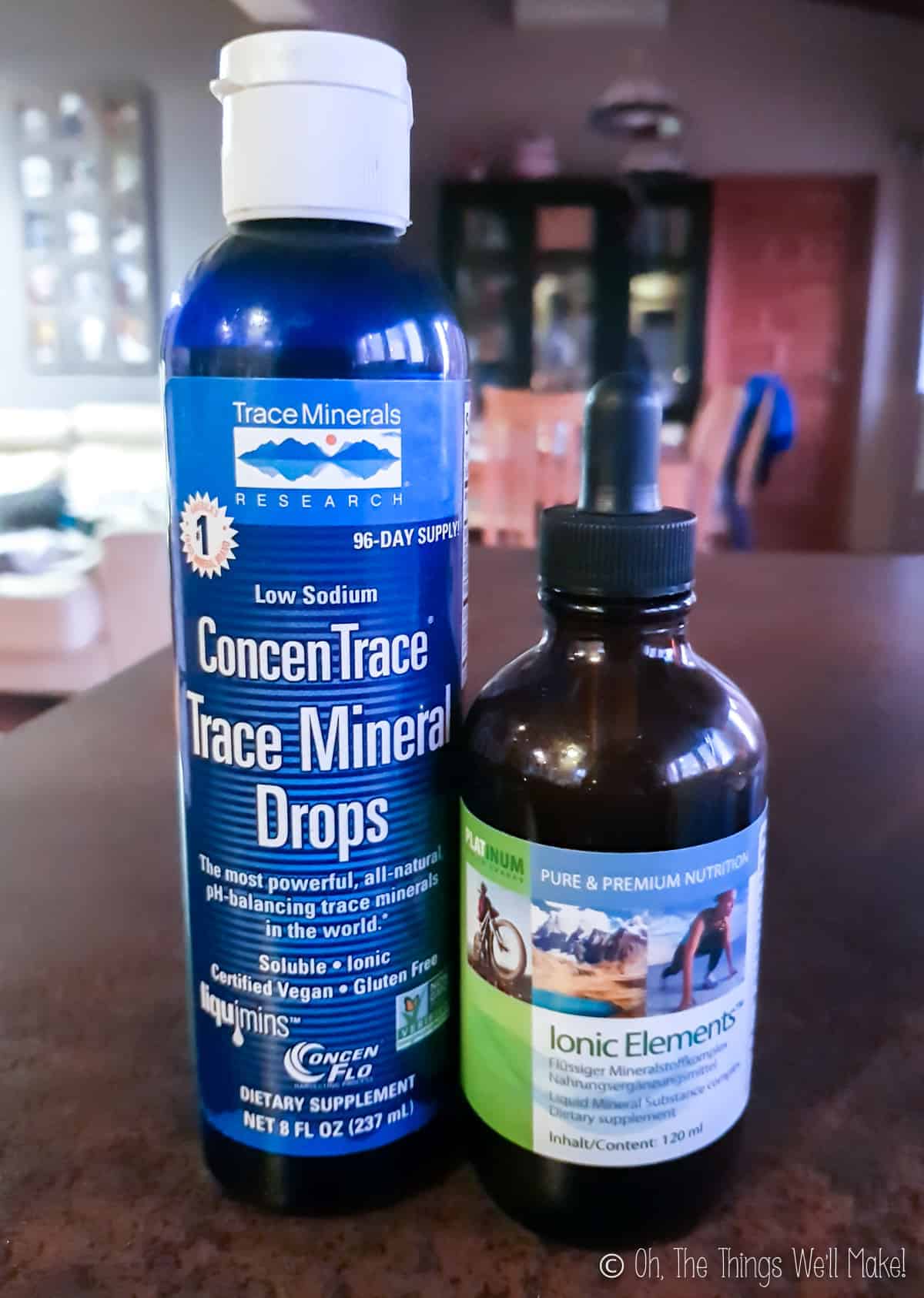 Two bottles of mineral supplements on a counter—one labeled "ConcenTrace Trace Mineral Drops," the other "Ionic Elements."