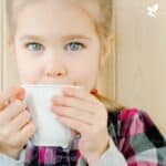 young girl sipping a cup of tea.