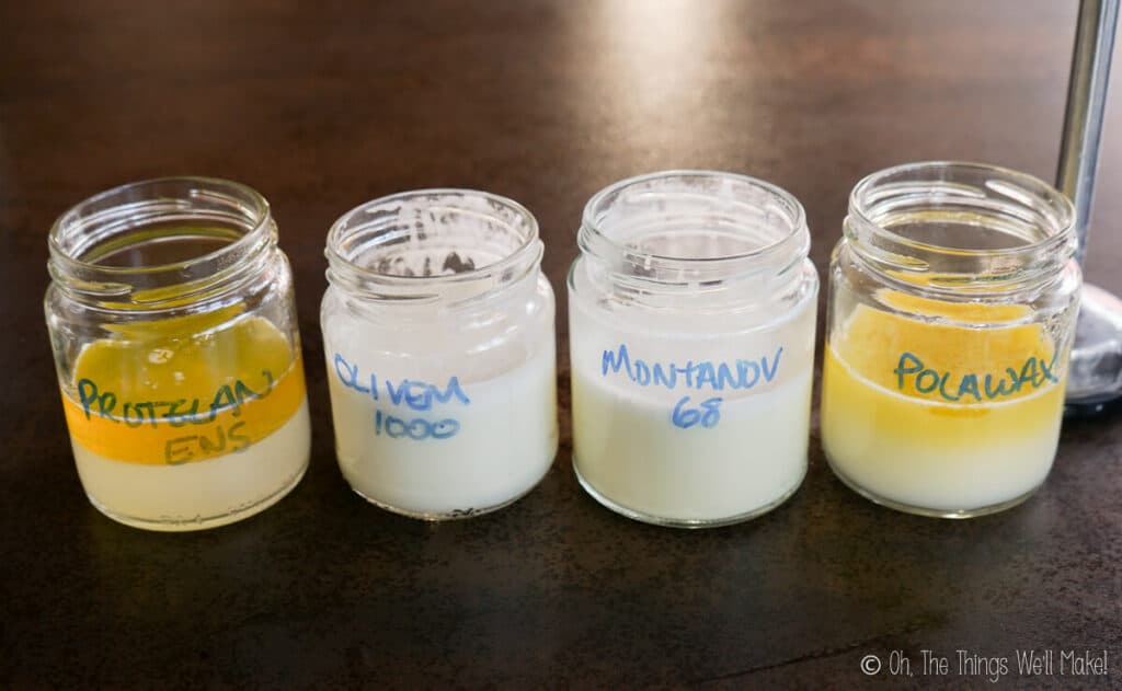 A closeup of 4 jars of homemade lotion in various stages of fabrication. Two of them have been blended and emulsified into lotions and two fo them are still in separate layers. 