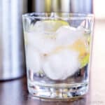 Closeup of a glass of carbonated water with ice, garnished with a slice of lime.