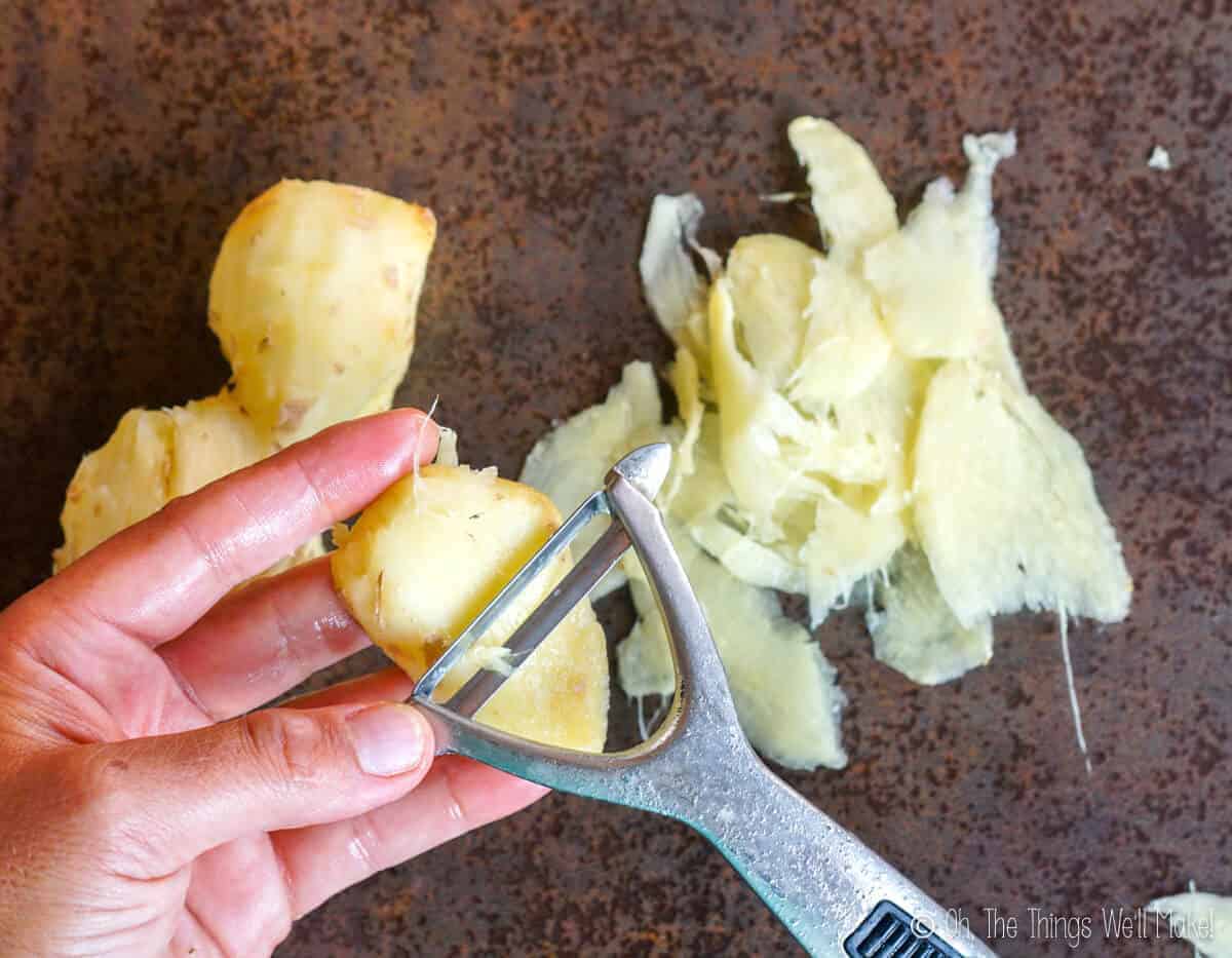 slicing a ginger root with a vegetable peeler