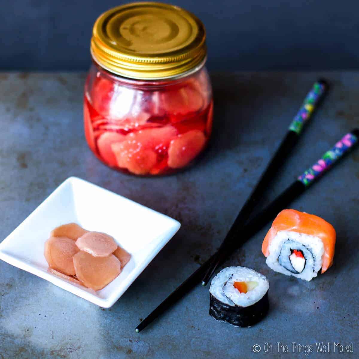 A jar of homemade pickled ginger for sushi next to some sushi and chopsticks