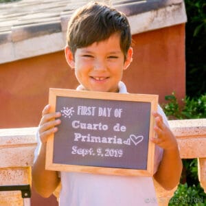Closeup of boy holding a chalkboard sign on the first day of school