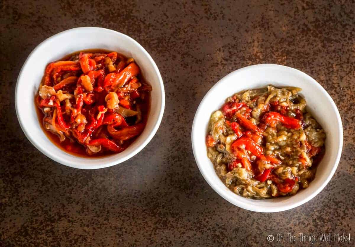 Overhead view of 2 bowls of roasted vegetables. The one on the left is esgarraet made with only red peppers. The one on the right is filled with espencat (roasted eggplant and red peppers).