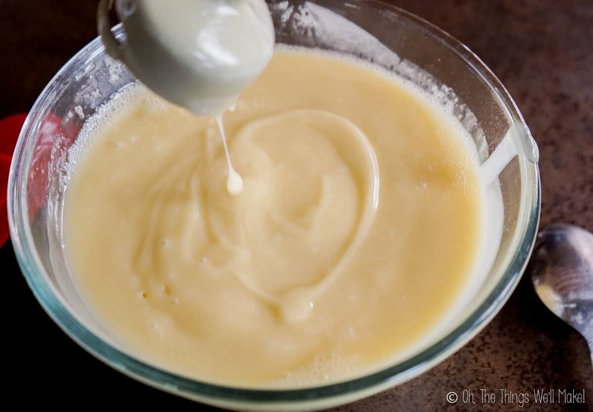 A bowl of soap mixture at trace, showing how the mixture is thickened and leaves a mark on top when a small amount of mixture is drizzled over the top.