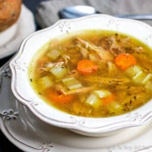 Closeup of a turkey soup with celery, carrots, and turkey pieces in view.