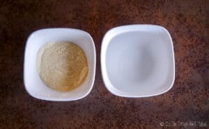 A bowl of goat milk powder next to a bowl of water