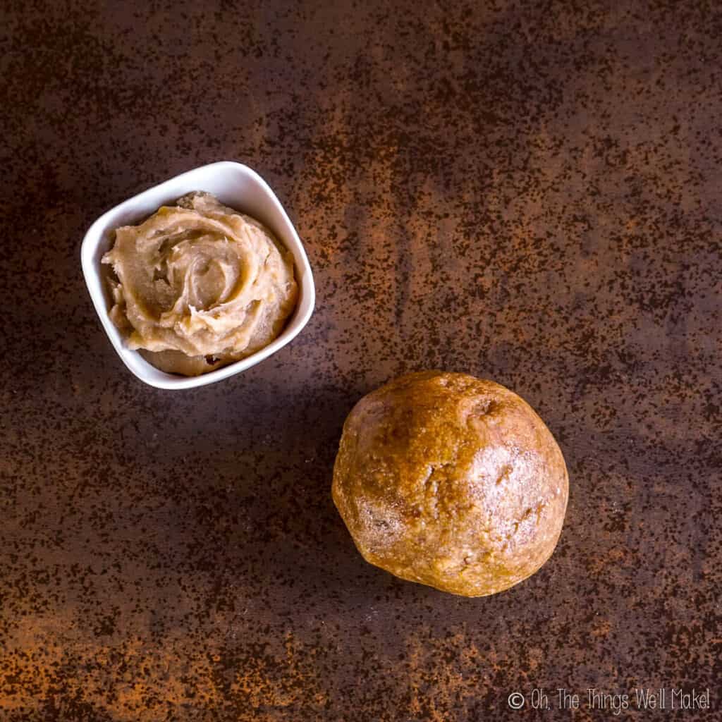 Overhead view of a ball of almond dough and a bowl of dulce de boniato filling