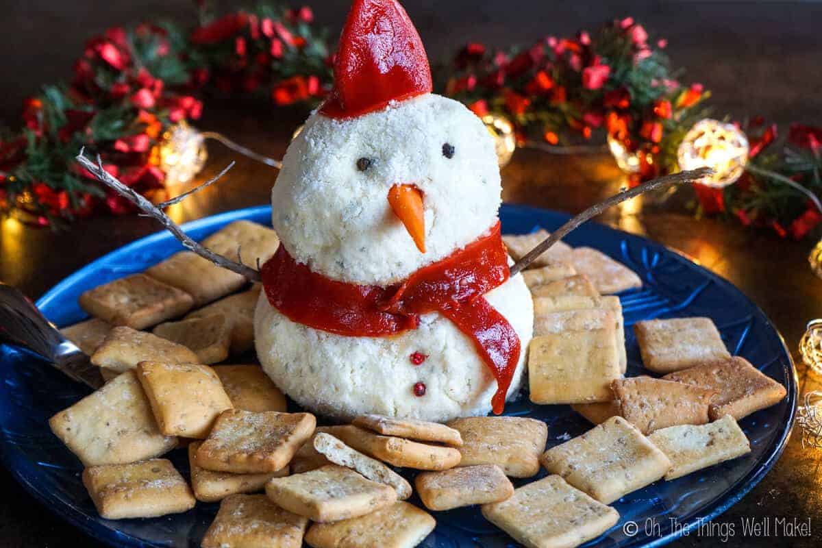 A snowman cheese ball surrounded by crackers
