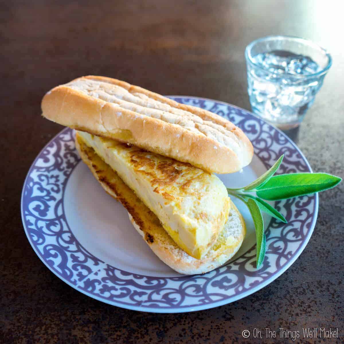 Spanish tortilla in a sandwich on a plate.