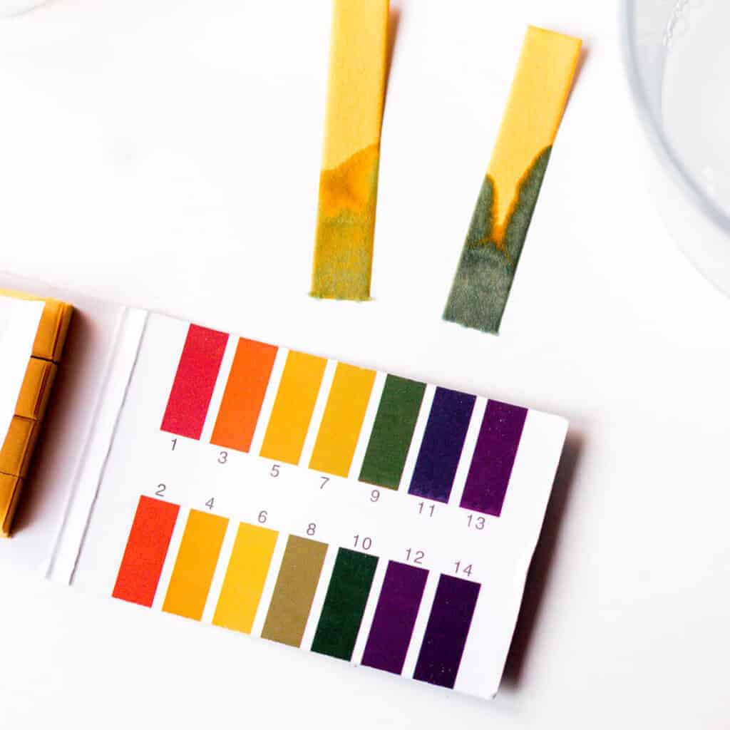 pH test strips next to the color chart to determine the pH