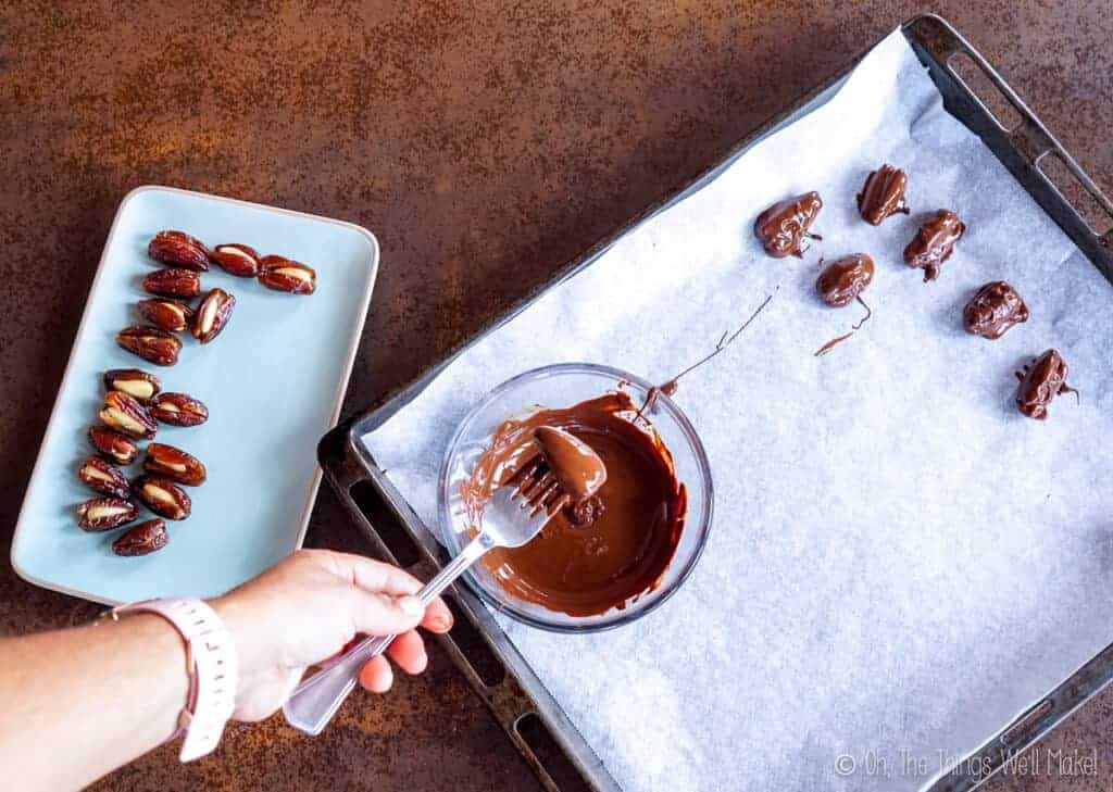 dipping dates into melted chocolate