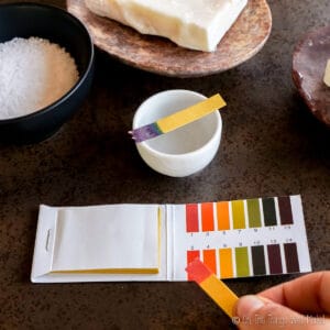 comparing a red pH strip to the pH chart
