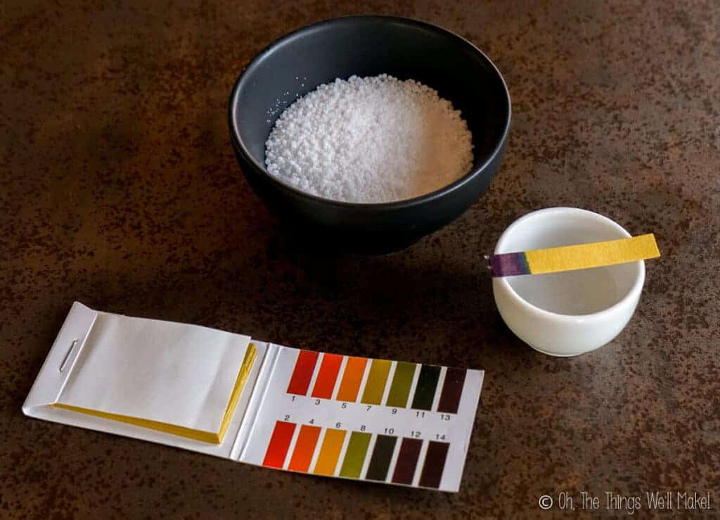 sodium hydroxide in a bowl next to pH test strips
