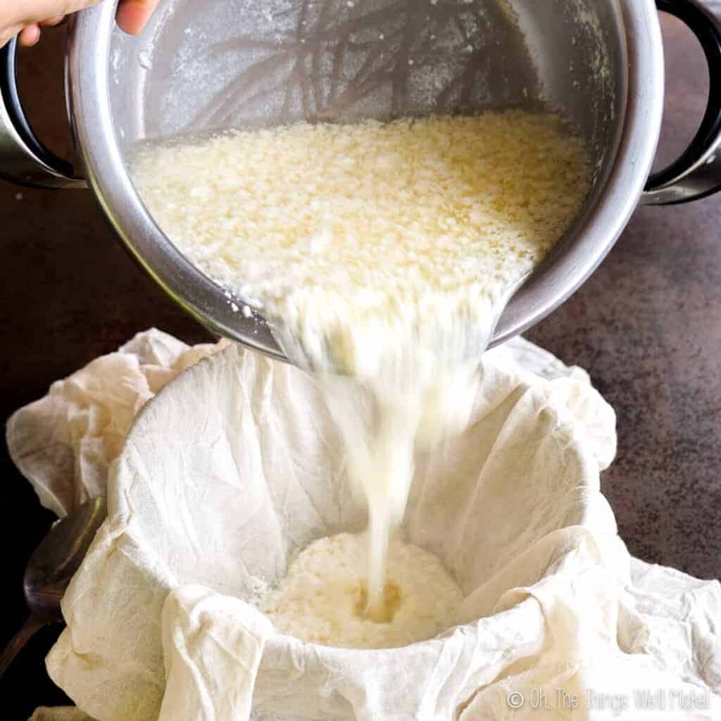 Pouring a curdled milk mixture into a bowl lined with cheesecloth
