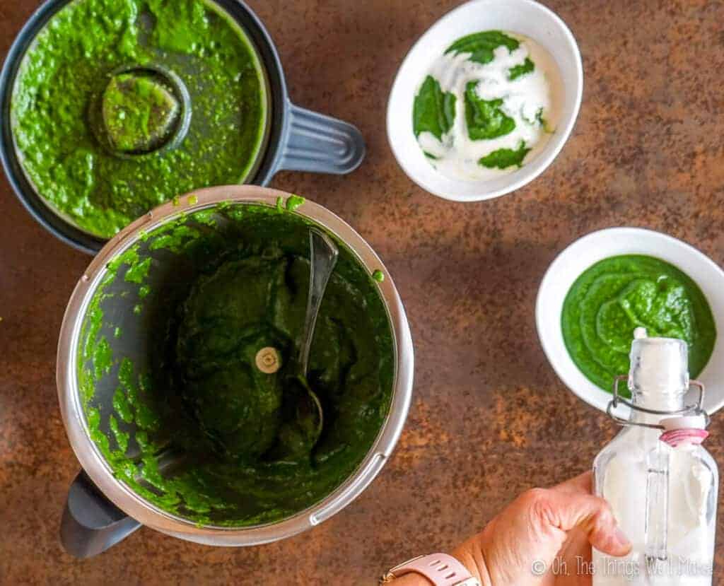 pouring cream over the bowls of puréed spinach