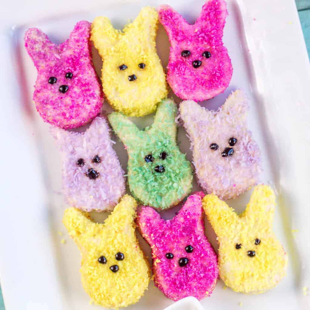 Overhead view of homemade marshmallow peeps decorated in colorful coconut sprinkles.